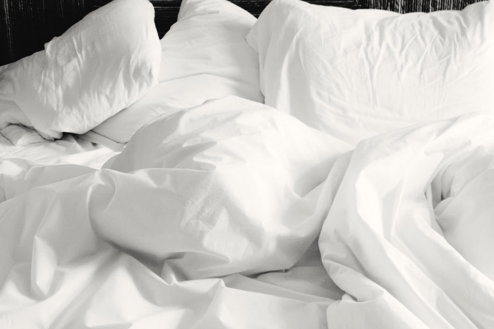 Soft white bed linen in morning light